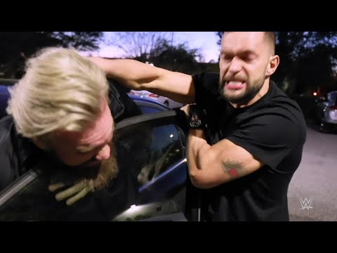 Finn Bálor jumps Trent Seven in a automotive parking lot